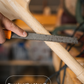 Hand using a sanding block to rasp a wooden handle, with 'Rasping the Handle' text - Trogon Cricket
