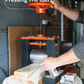 Person using a manual press tool with text 'Pressing The Cleft' in a workshop setting - Trogon Cricket