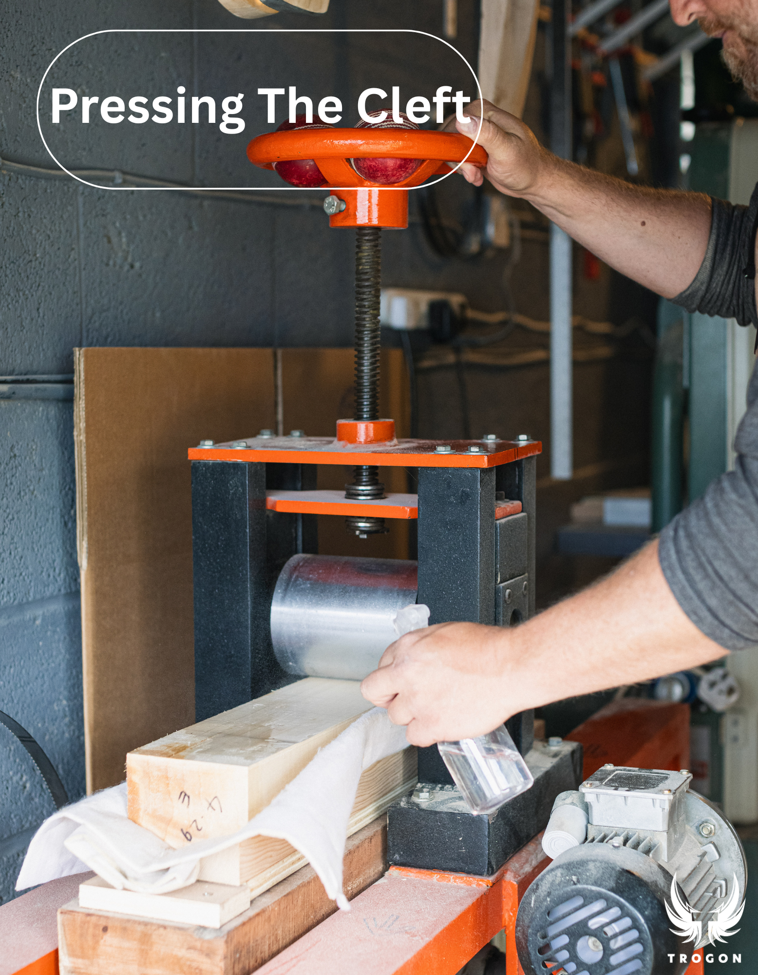 Person using a manual press tool with text 'Pressing The Cleft' in a workshop setting - Trogon Cricket