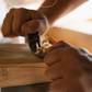Person using a hand tool on a wooden surface with 'Shaping the Willow' text and Trogon logo.