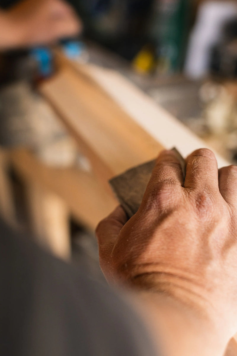 Sanding a cricket bat by hand